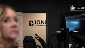Ignite Performance and Health gym with strength-training equipment and a blurred woman in the foreground.