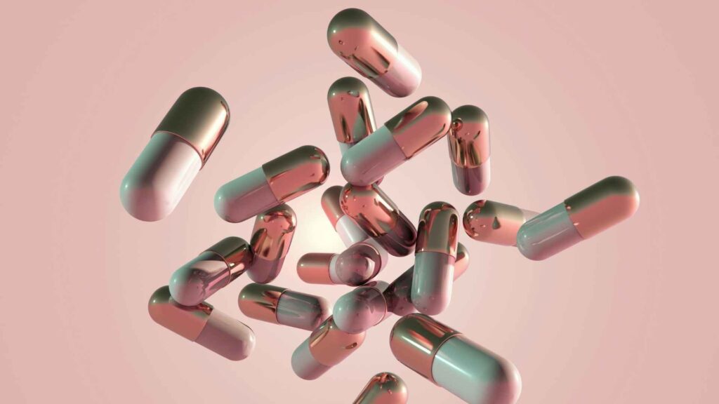 Abstract metallic capsules floating against a pink background, representing recovery peptide treatments.