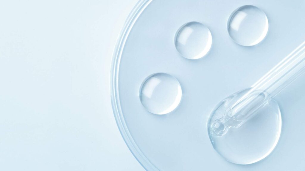 Clear serum drops and a glass dropper representing hormone therapy and peptide treatment options.