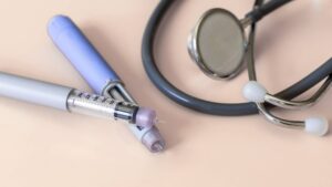 Medical injection pens and a stethoscope representing clinician-guided weight-loss treatment options.