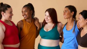 Diverse group of women in activewear smiling together, representing sustainable fitness and metabolic health.